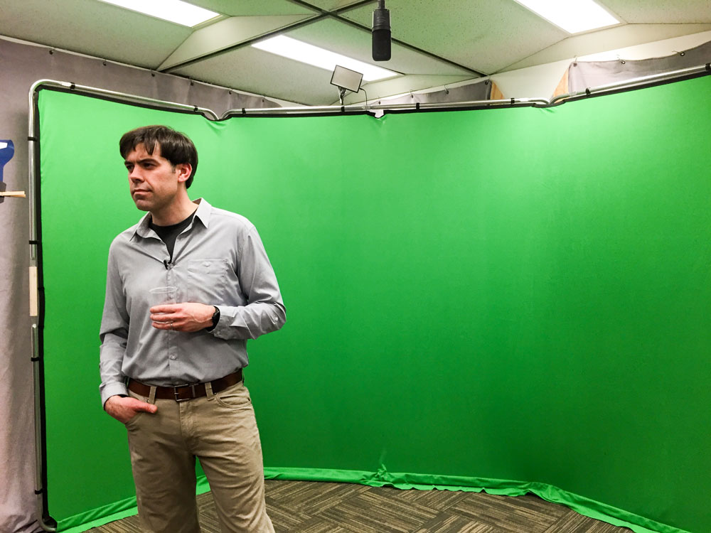 Dr. Zac Robinson filming for Mountains 101 in front of the green screen.
