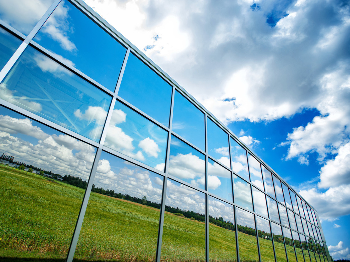 Reflection of fields on the south campus farm glass facade