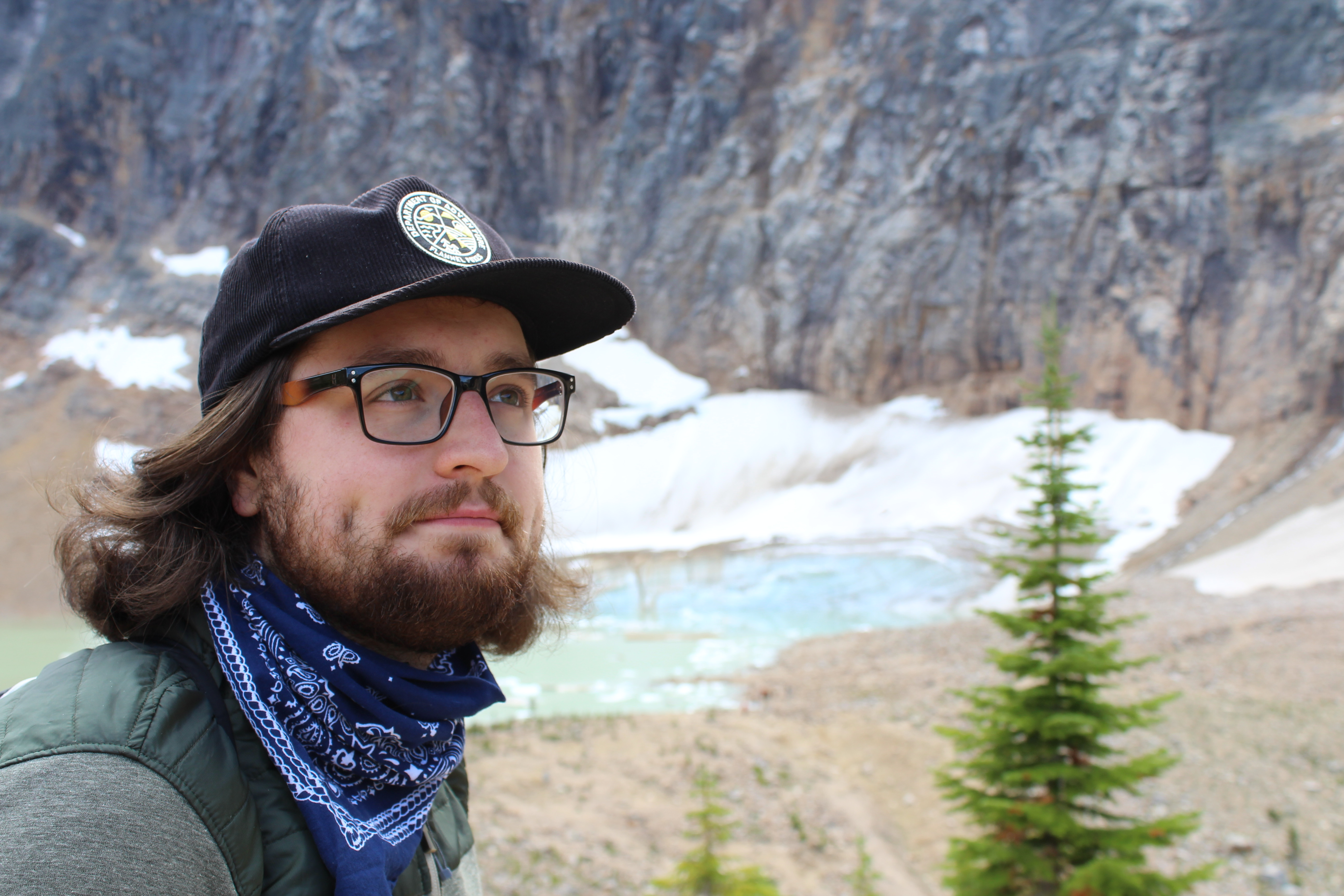 Portrait of William in front of lake/glacier in the mountains.