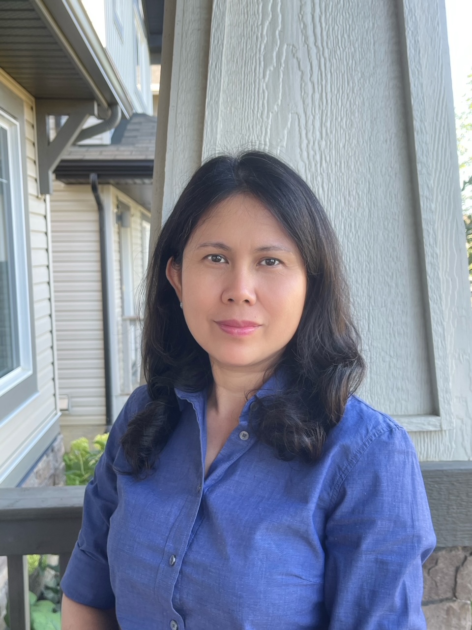 Duyen poses respectfully on an outdoor porch