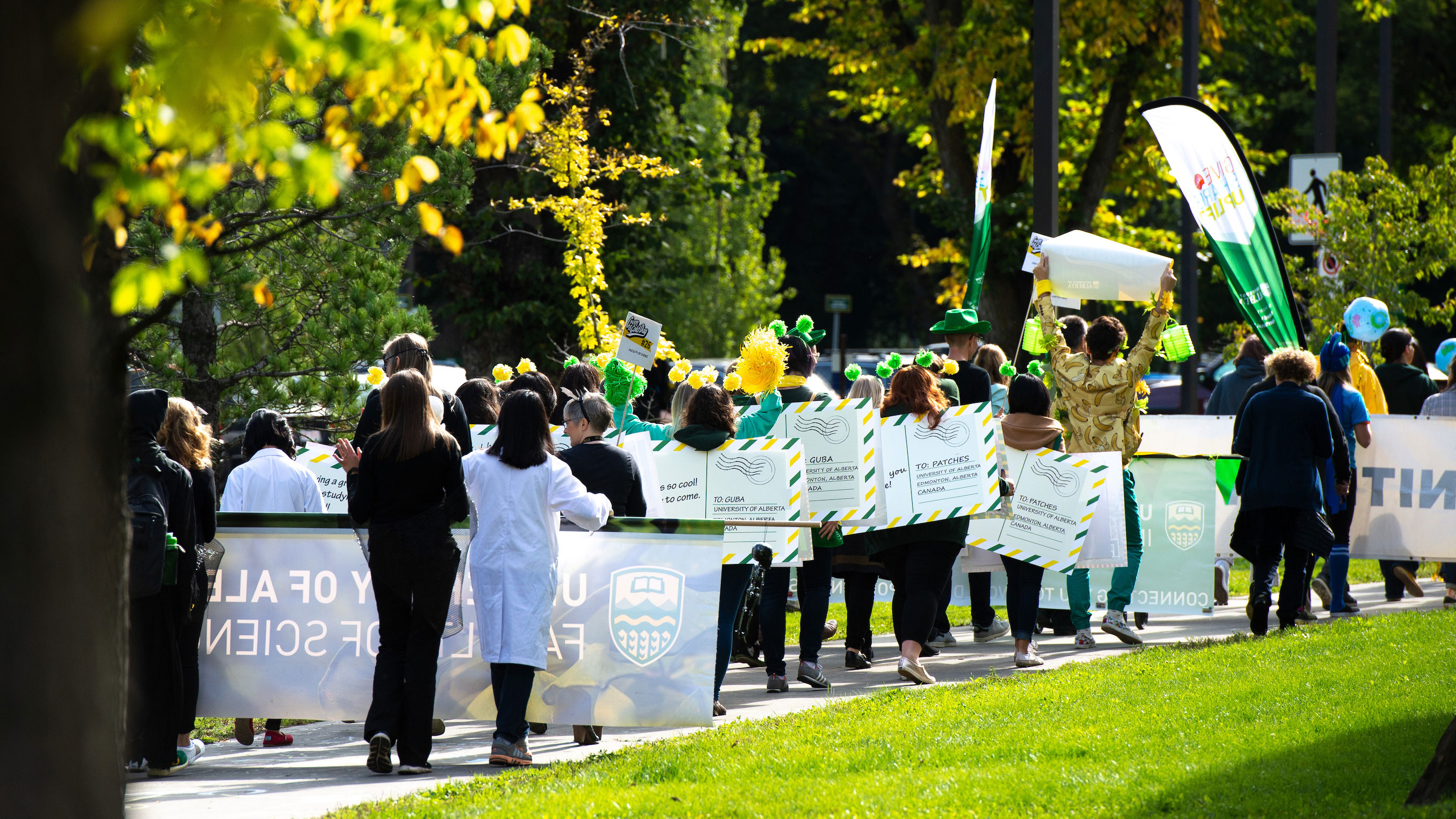 green and gold parade with people celebrating the U of A