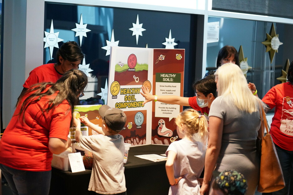 ALI booth staff and volunteers teach attendees about soil health