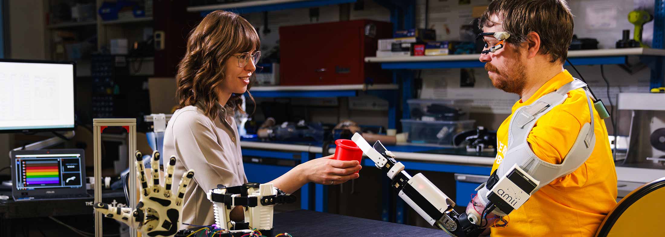 Amii roboticist works with a client with a robotic arm