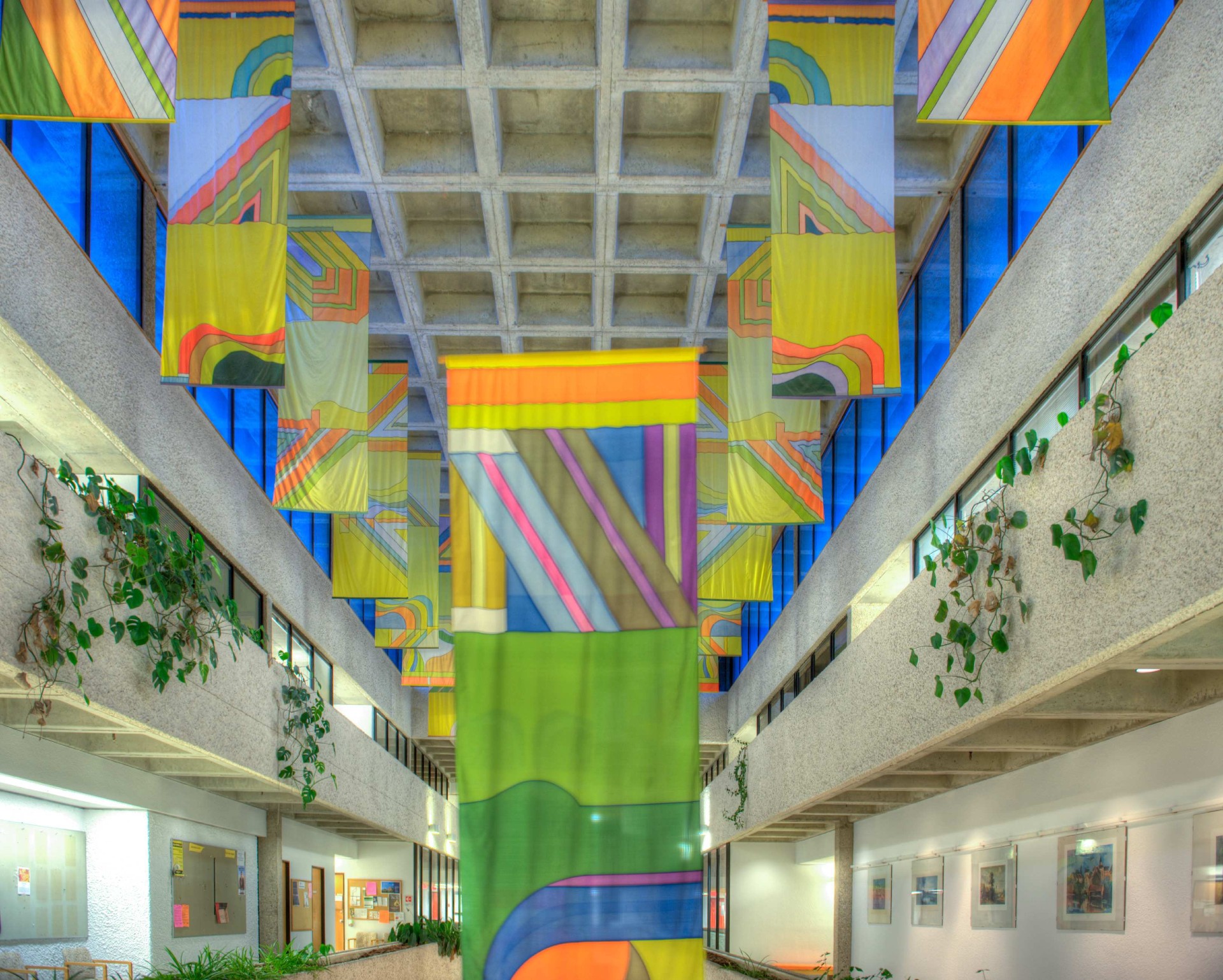 Hallways decorated with multi-coloured skylights, bright carpets, and painted nylon banners by Canadian artist Takao Tanabe