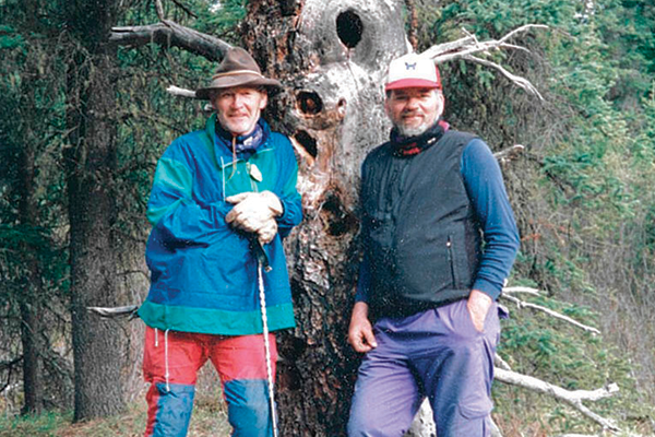 Garry Gibson and Doc Larson leaning against a tree.