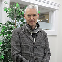 A photo of Alexander Carpenter wearing a jacket and a scarf. 