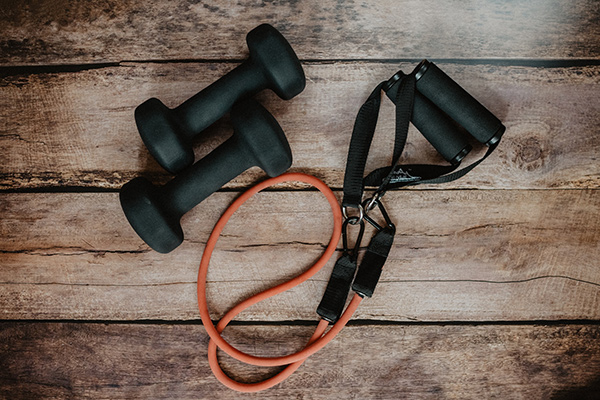 A photo of exercise equipment including small dumbbells and a resistance band. 