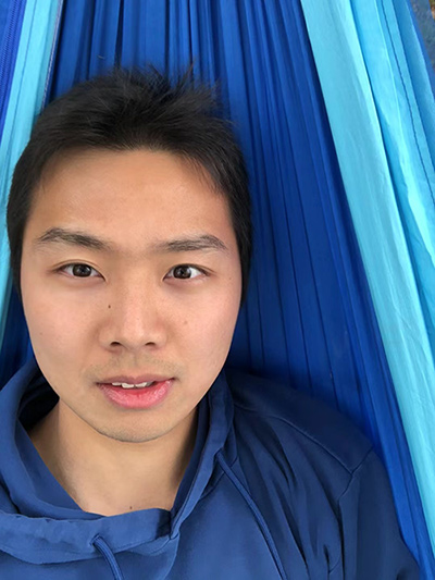 A photo of Jiayi Dai in front of a blue background.