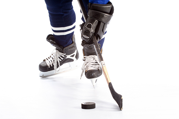 photo of hockey player on ice, in equipment, from mid shin down.