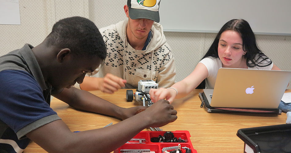 A photo of students programming a robot in a robotics class