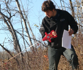 A student with a measuring tape in autumn