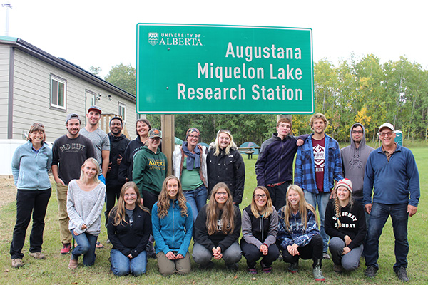 Students and instructors standing in front of the Research Station sign