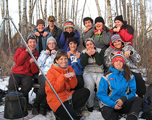 A group of students and instructors posing like beavers for the camera