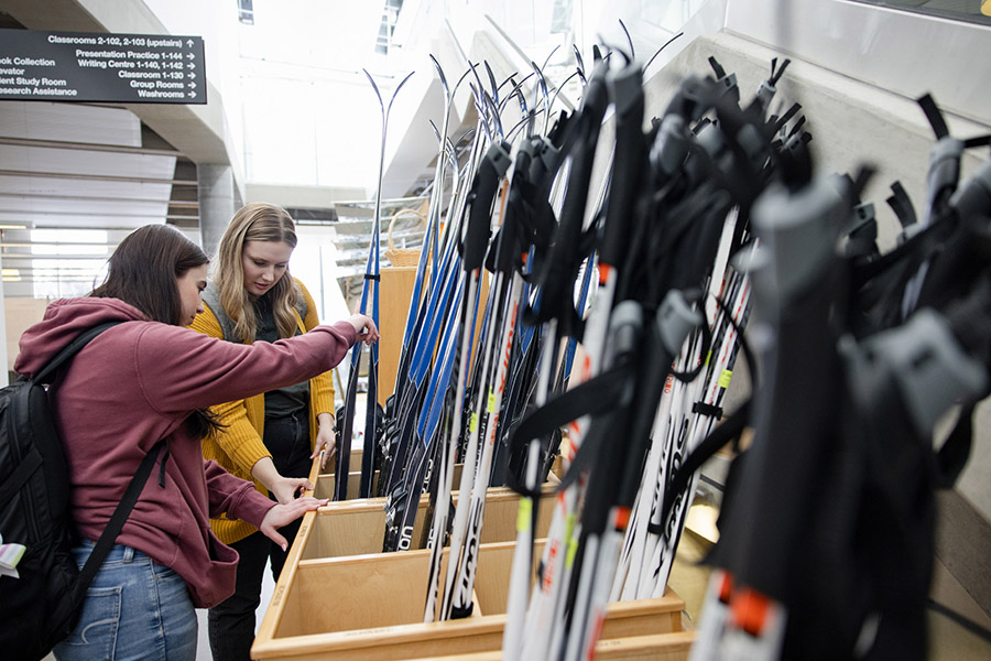 Students looking through skis in the ski library.