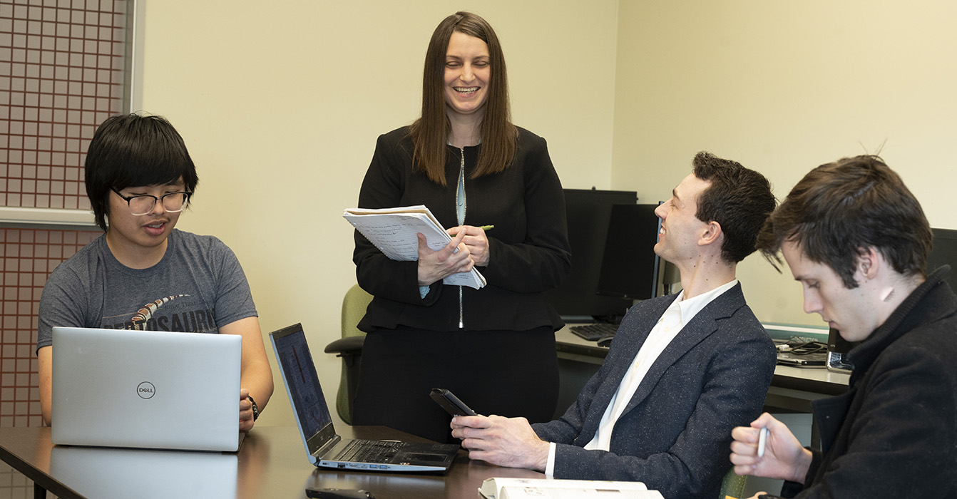 PhD students laugh while reviewing material together.