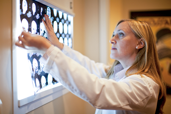 Picture of a female physician looking at MRI scans.