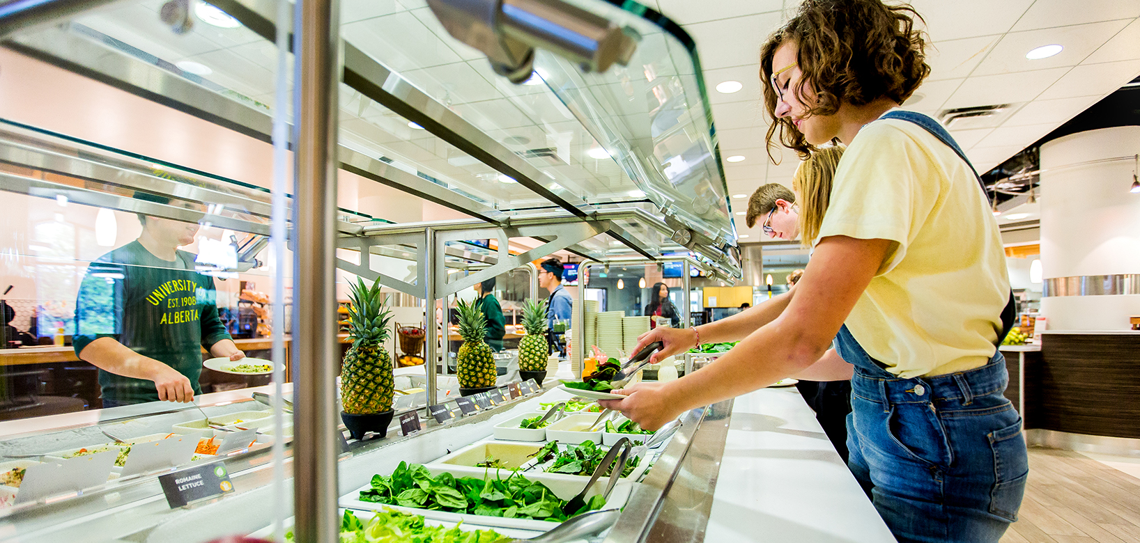 Student dishing up at the salad bar
