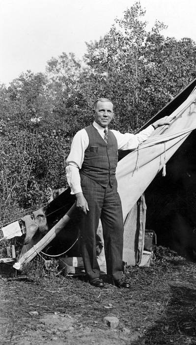 Dr. John A. Allan standing outside a trapper's tent