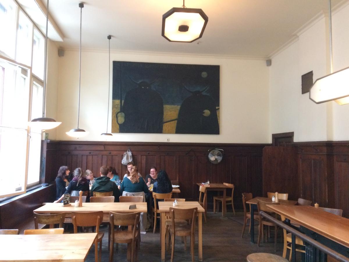 students sitting at table beneath the painting illustrated in Tim Dinter’s comic adaptation of Sven Regener’s novel Herr Lehman. 