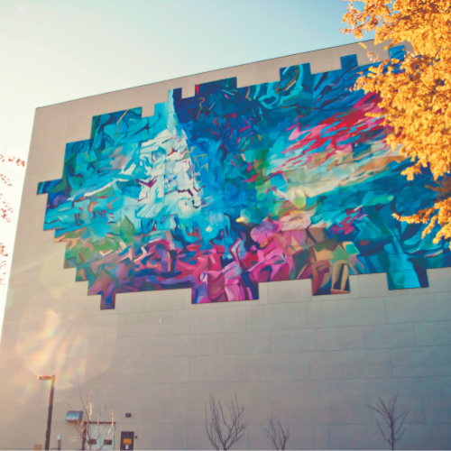 Outside of Education building with autumn leaves and mural