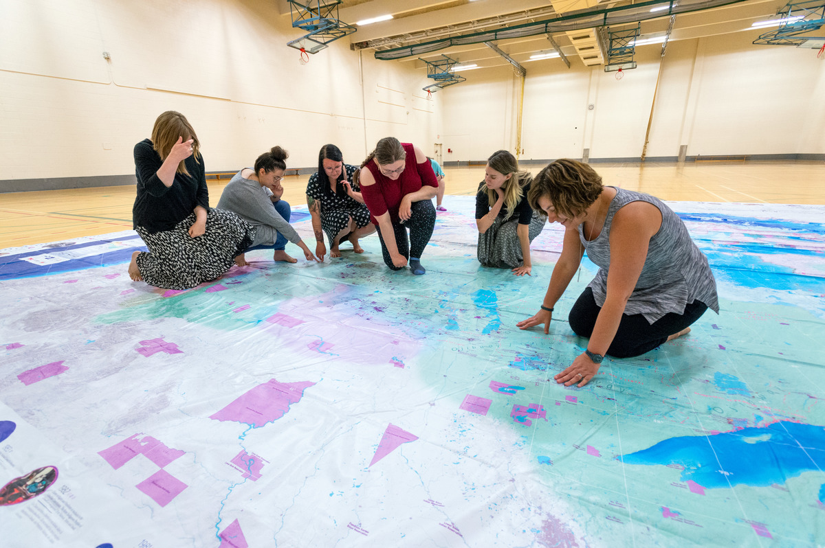 several people crouched on a large map engaging in a treaty map exercise 