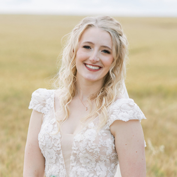 Photo of Kahlie posing outside in a wheat field