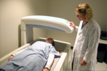 A person laying on a bed with the duel energy xray machine