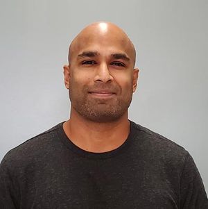 An image of Dr. Ashantha Ranasinghe, a man wearing a dark t-shirt in front of a gray backdrop.