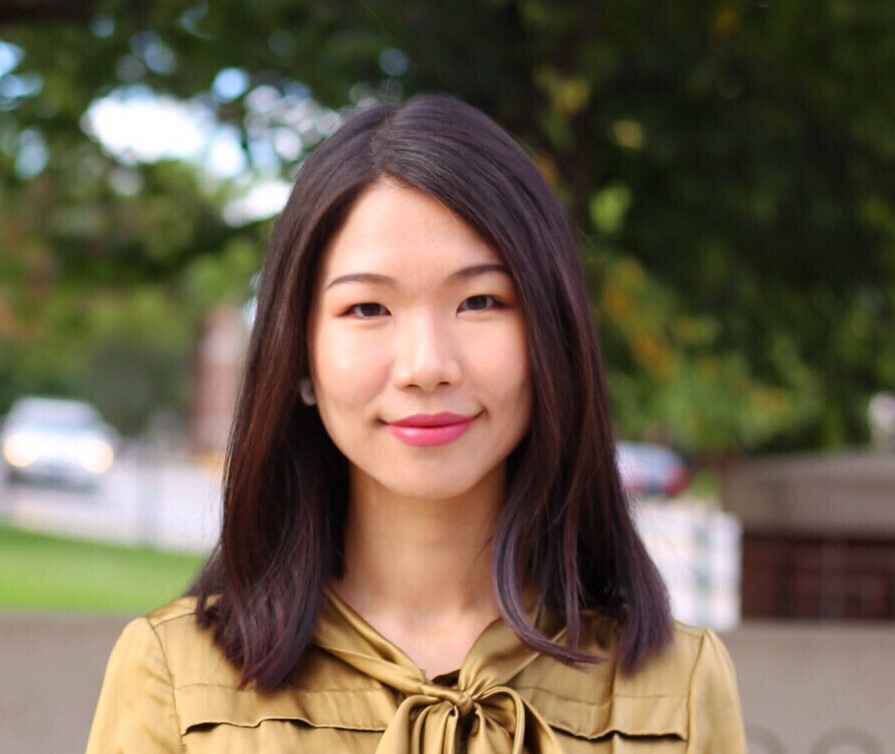 An image of Dr. Jiatong Zhong, a woman standing outside and wearing a yellow cardigan.