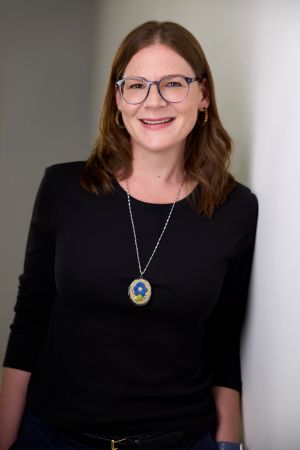 An image of Dr. Sarah Nickel, a woman wearing a dark sweater and an Indigenous fabric pendant.