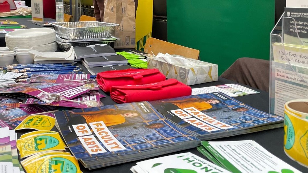 Angled view of a merchandise table at a Faculty of Arts event