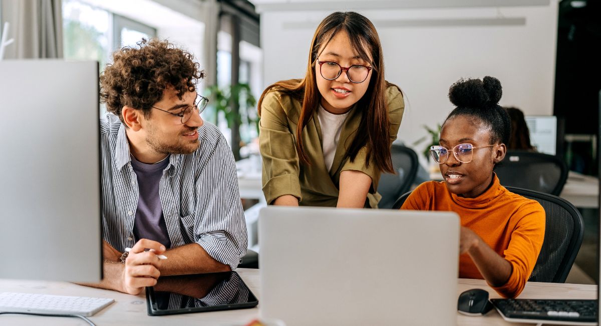 Three young colleagues discussing work at modern office