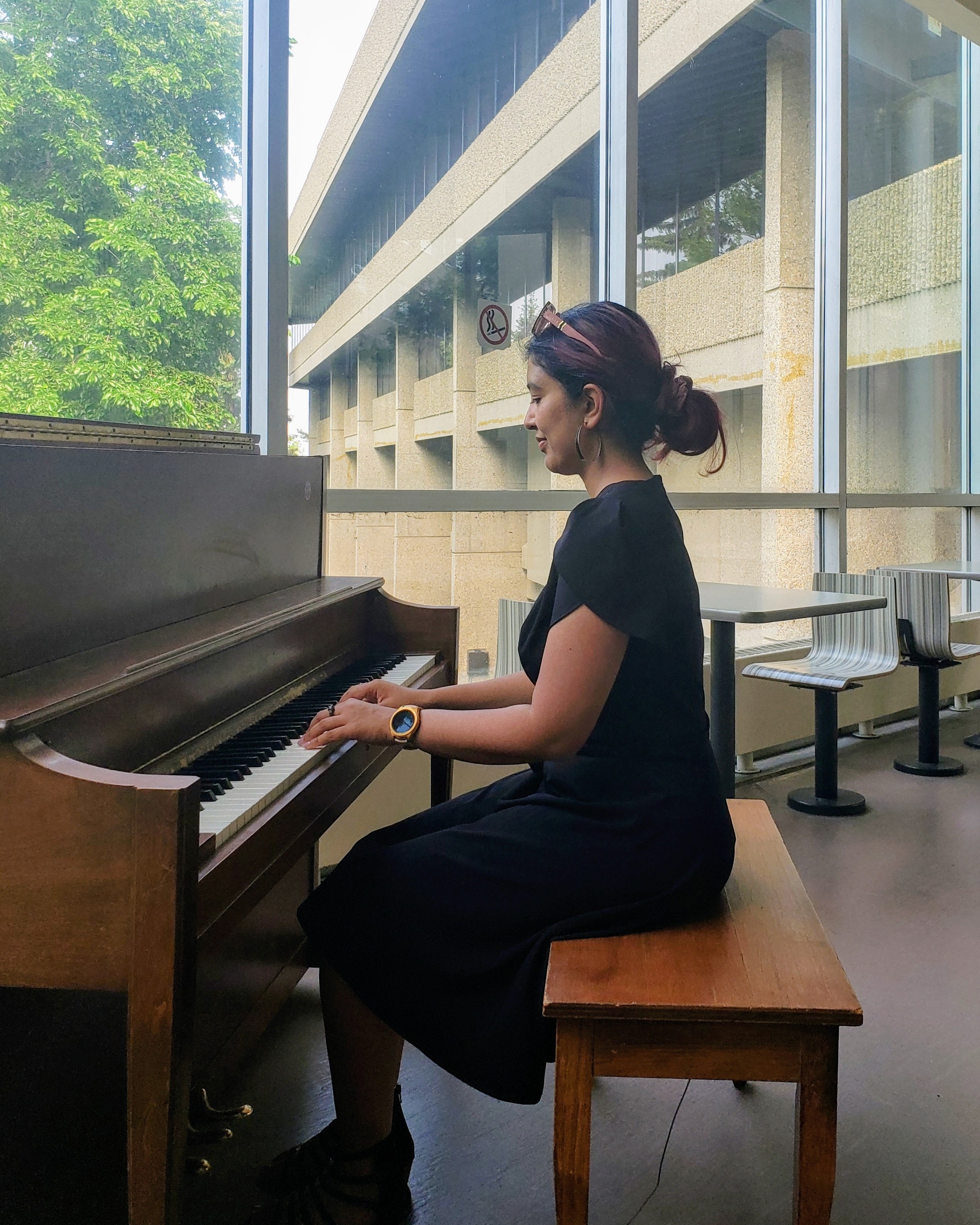 Monisha sitting at a piano playing.