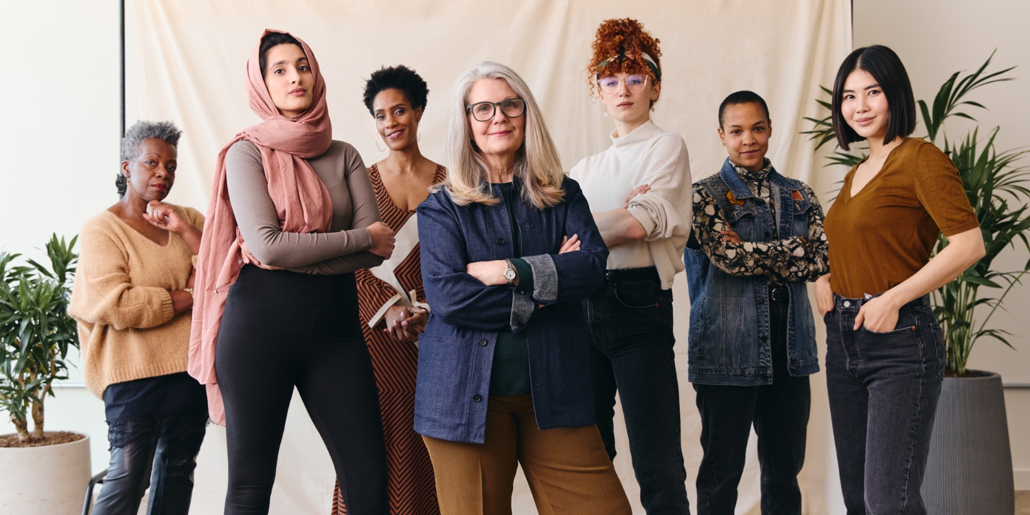 Six women of diverse ages and backgrounds stand together with confident expressions in a bright indoor setting. The image illustrates themes of entrepreneurship, leadership and innovation.