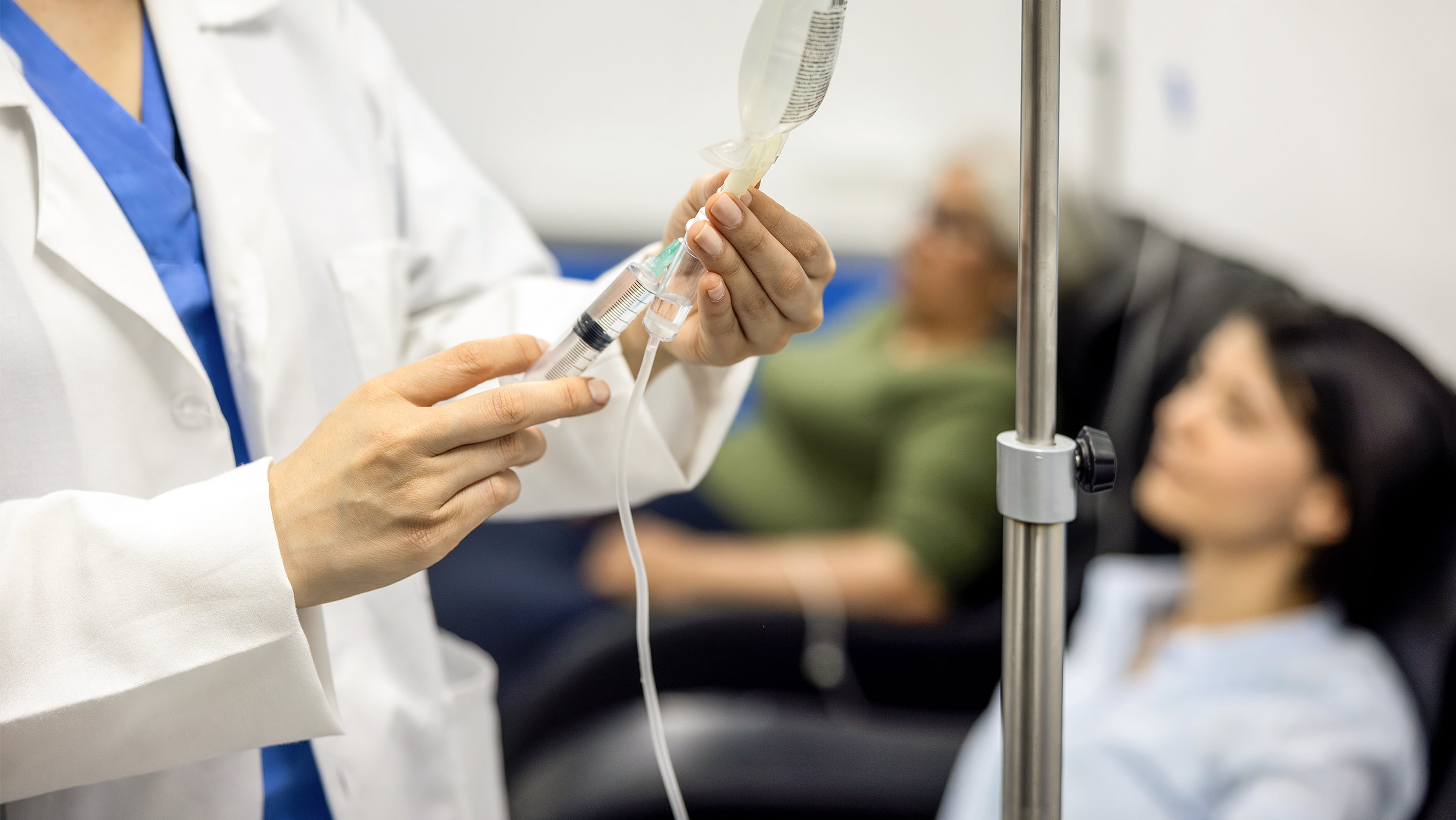 health care working injecting into IV bag