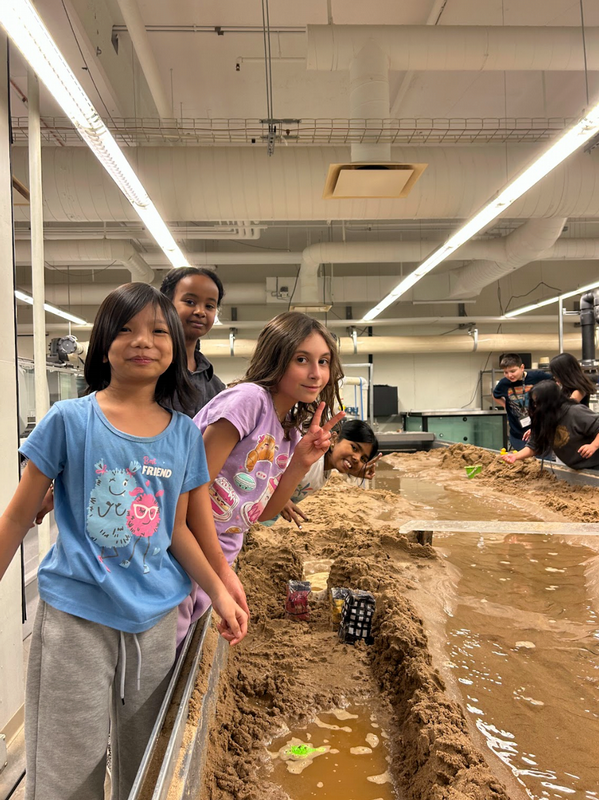 U School participants engaging in a session using a water table