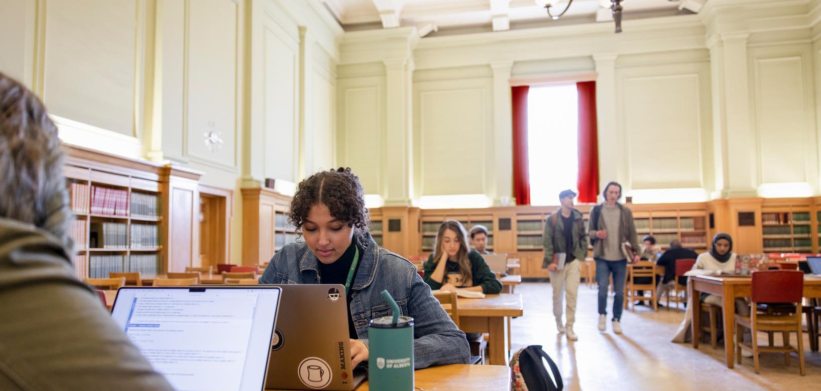 Students studying on laptops in library