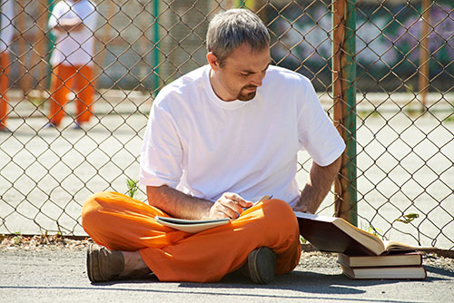 Incarcerated person studying in prison yard