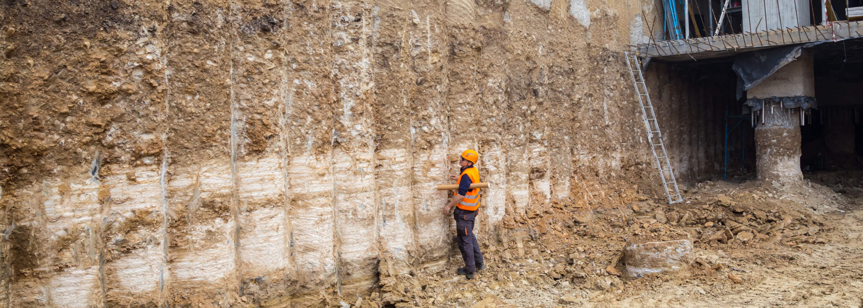 Construction worker checking pile retaining wall