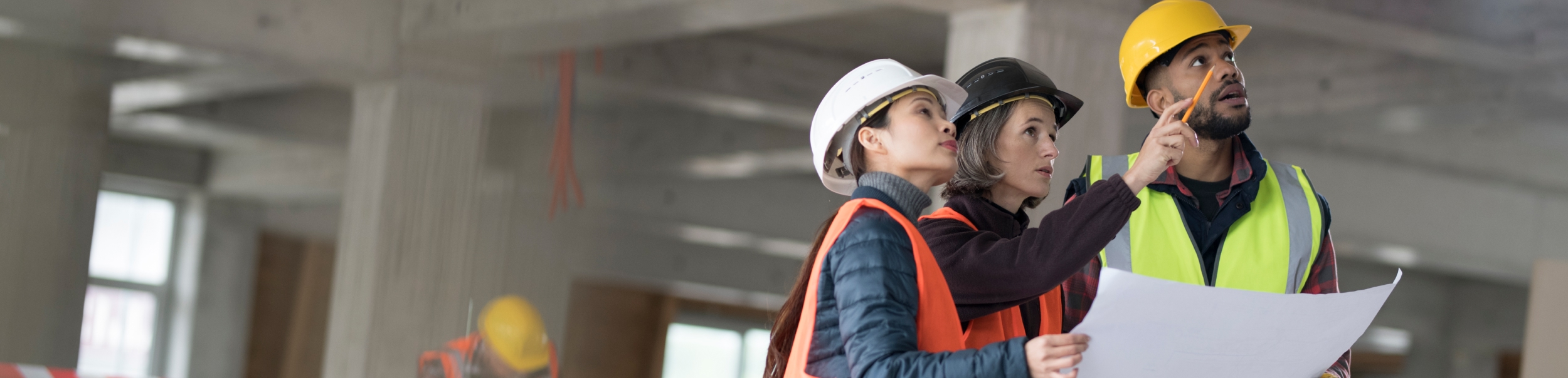 Architects discussing blueprint with construction worker