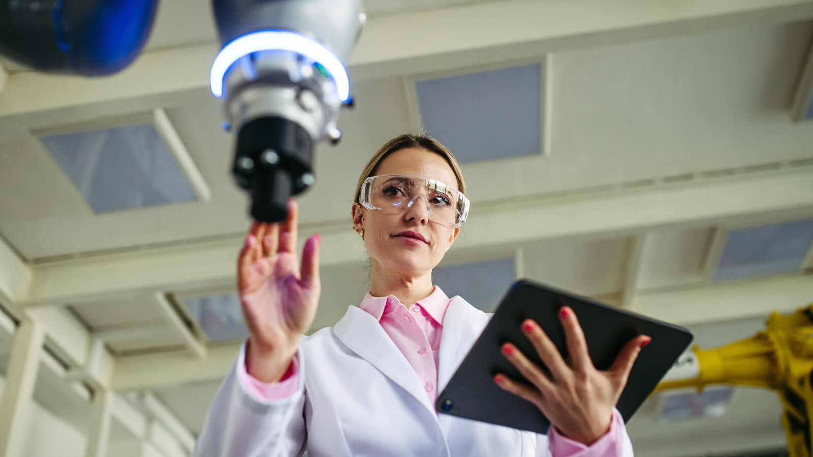 Female robotic engineer working on robotic knee replacement surgery project, checking data in tablet. Concept of robotics, engineering and computer science in healthcare.