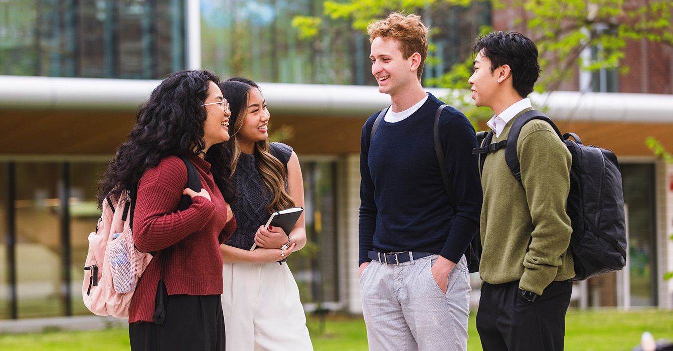 Students in the combined Business/Engineering masters program confer with each other outdoors.