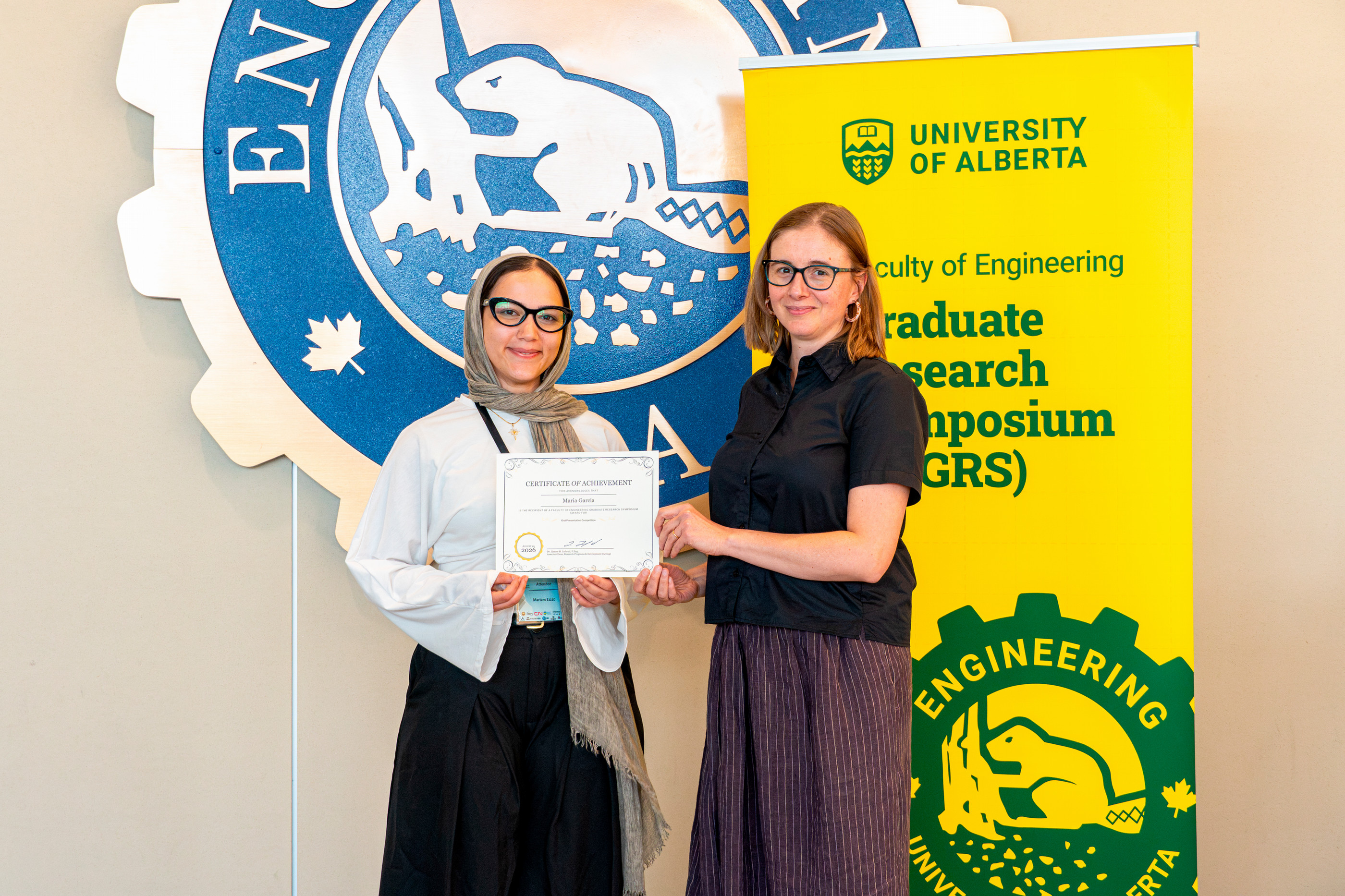 Two people posing with a certificate