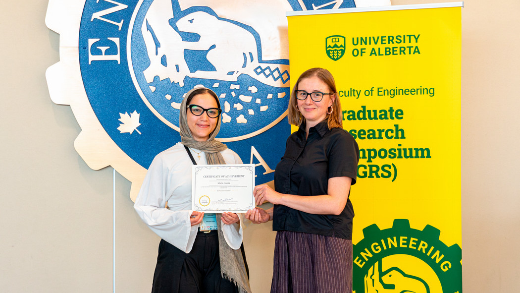Two people posing with a certificate