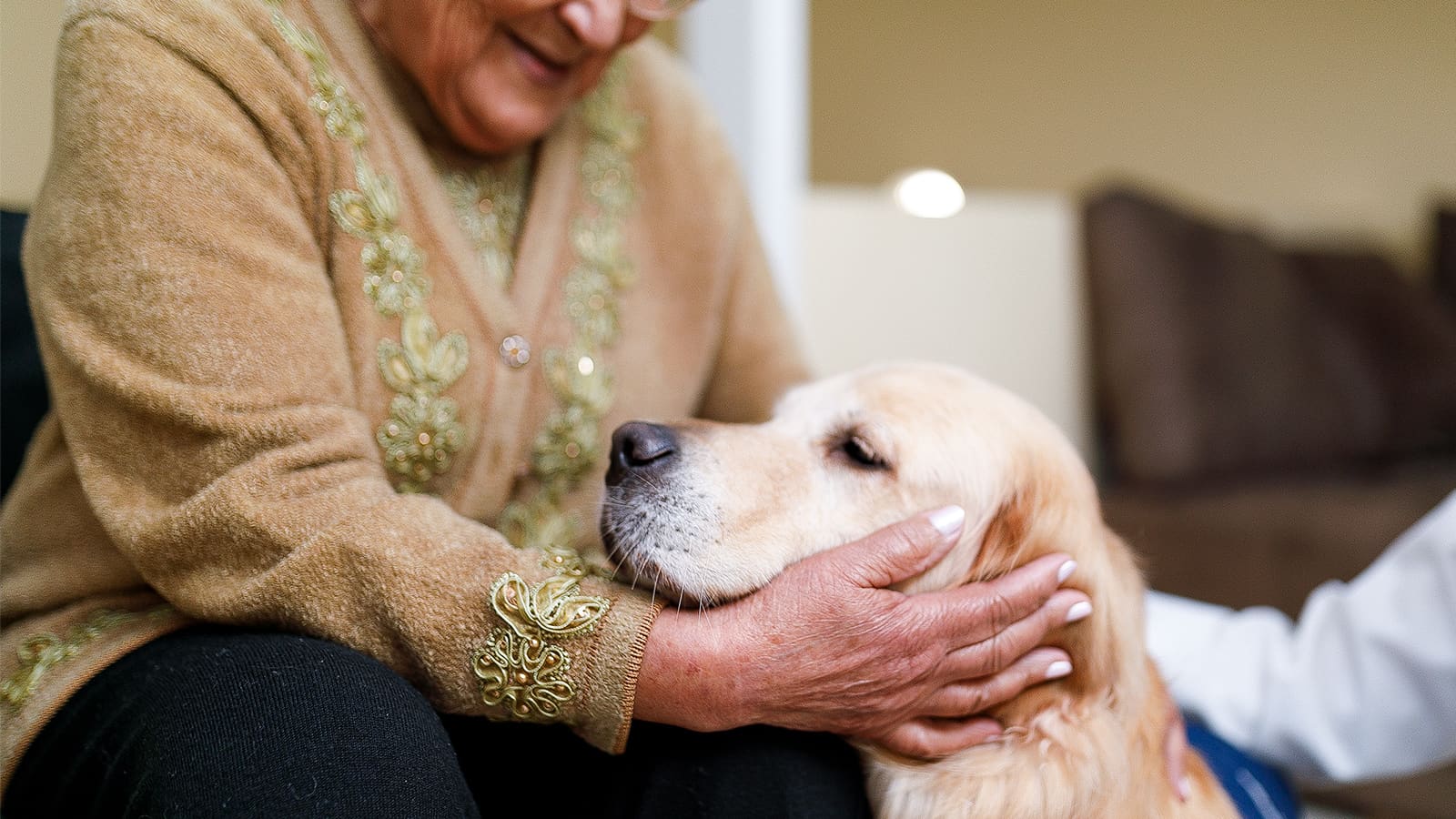 A senior woman cradles a dog's head. (Photo: Getty Images)
