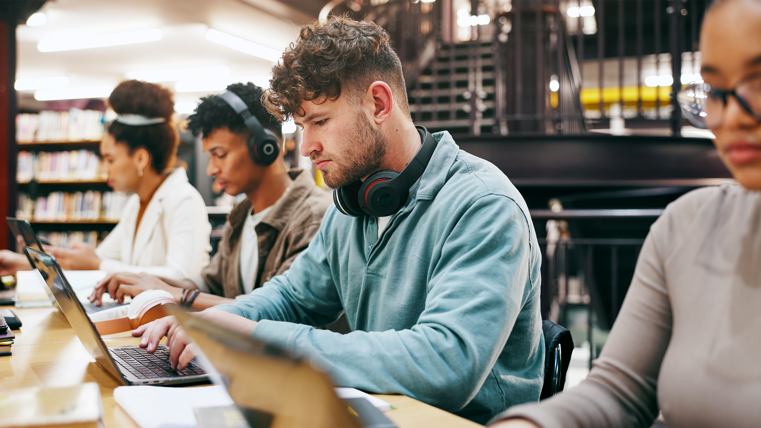 Students seated in a library work on their laptops. (Photo: Getty Images)