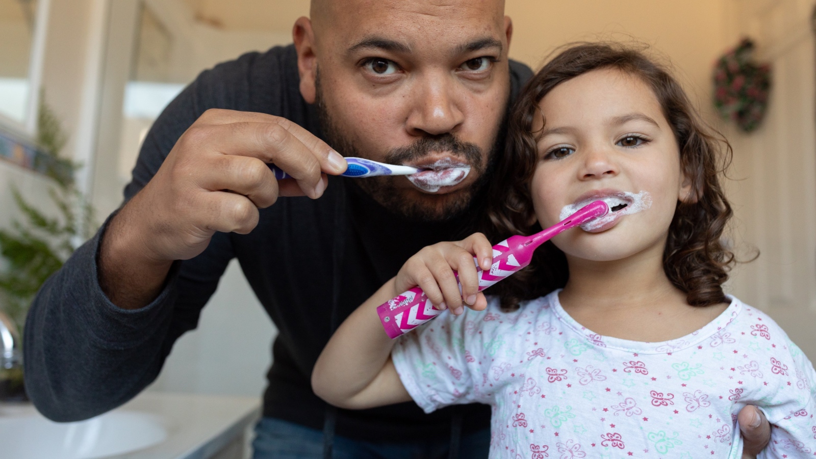 A father and daughter brush their teeth together. (Photo: Getty Images)