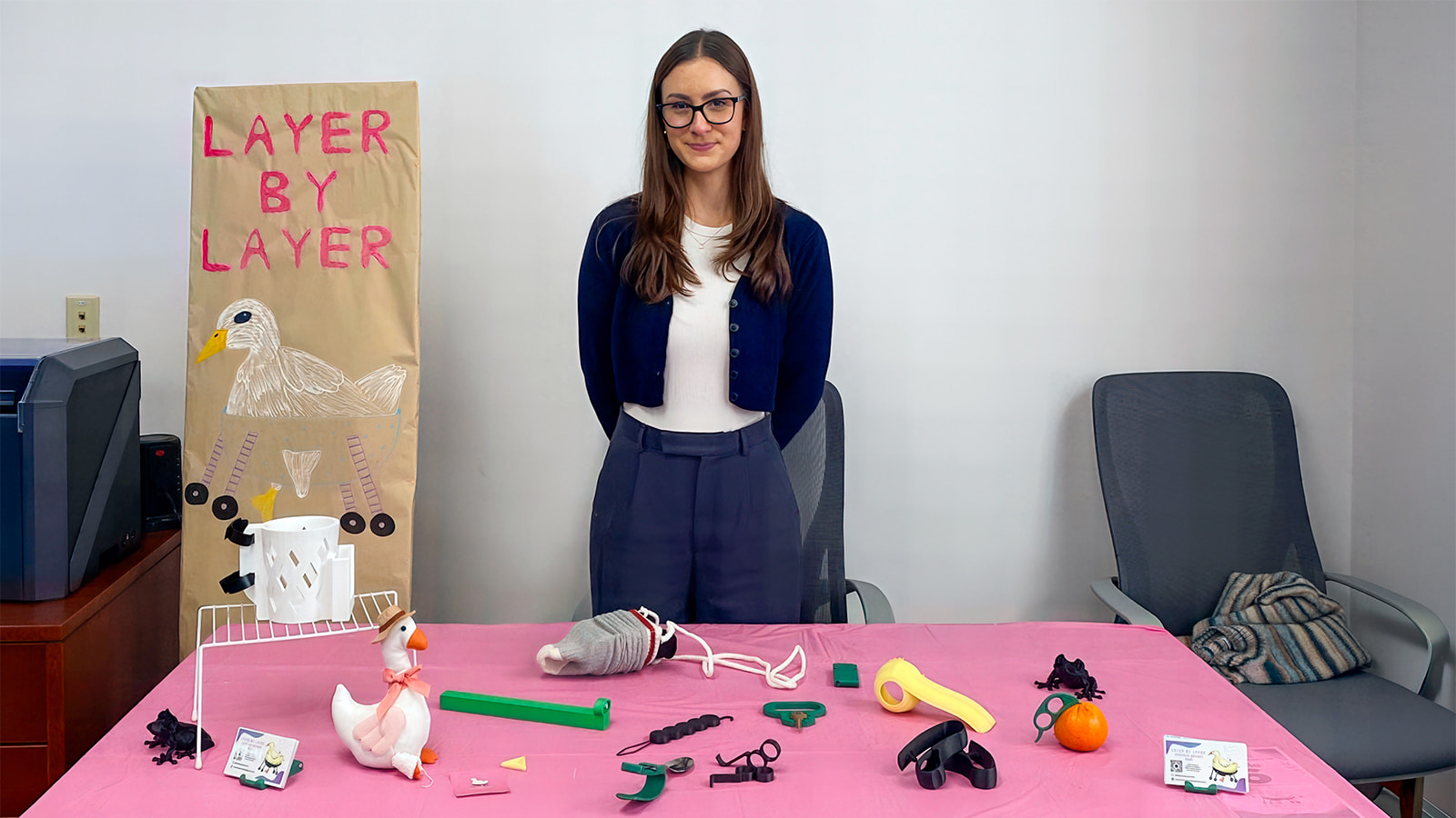 Occupational therapy student Vianna Aiello holding several 3D printed assistive devices made by her Layer By Layer club