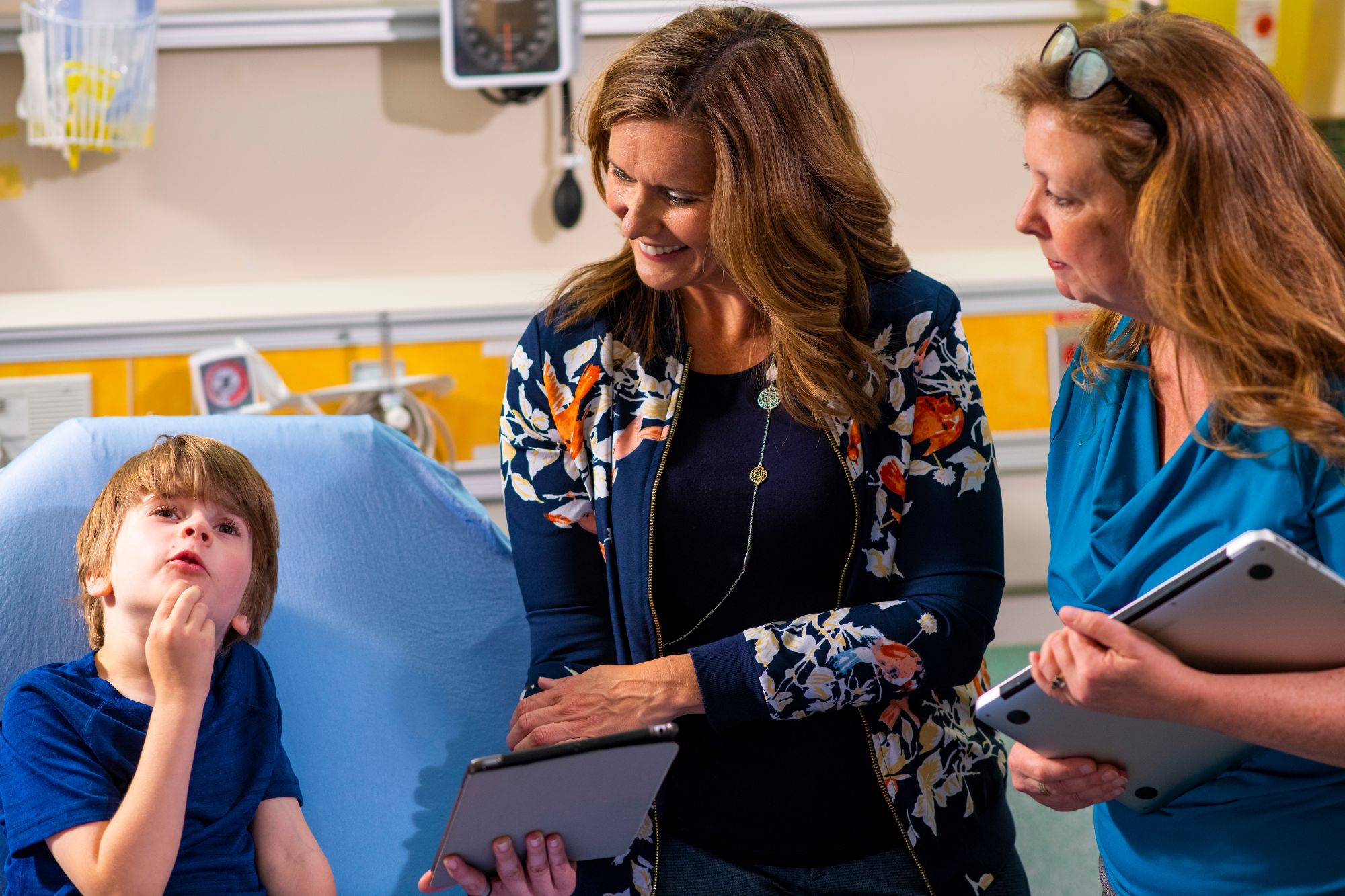 A mother and her young son at the hospital with a nurse