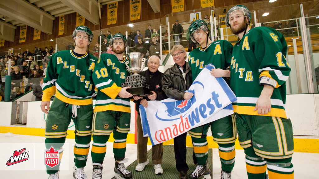 Clare Drake and Dale Schulha present the Canada West Conference championship trophy and banner to the Golden Bears men’s hockey team, circa early 1990s.